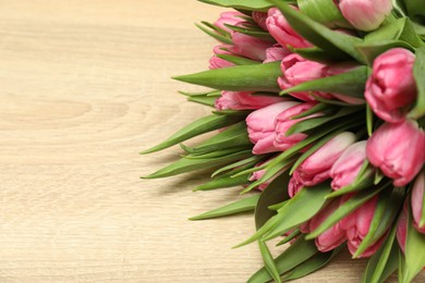 Photo of Bouquet of beautiful tulips on wooden table, closeup. Space for text