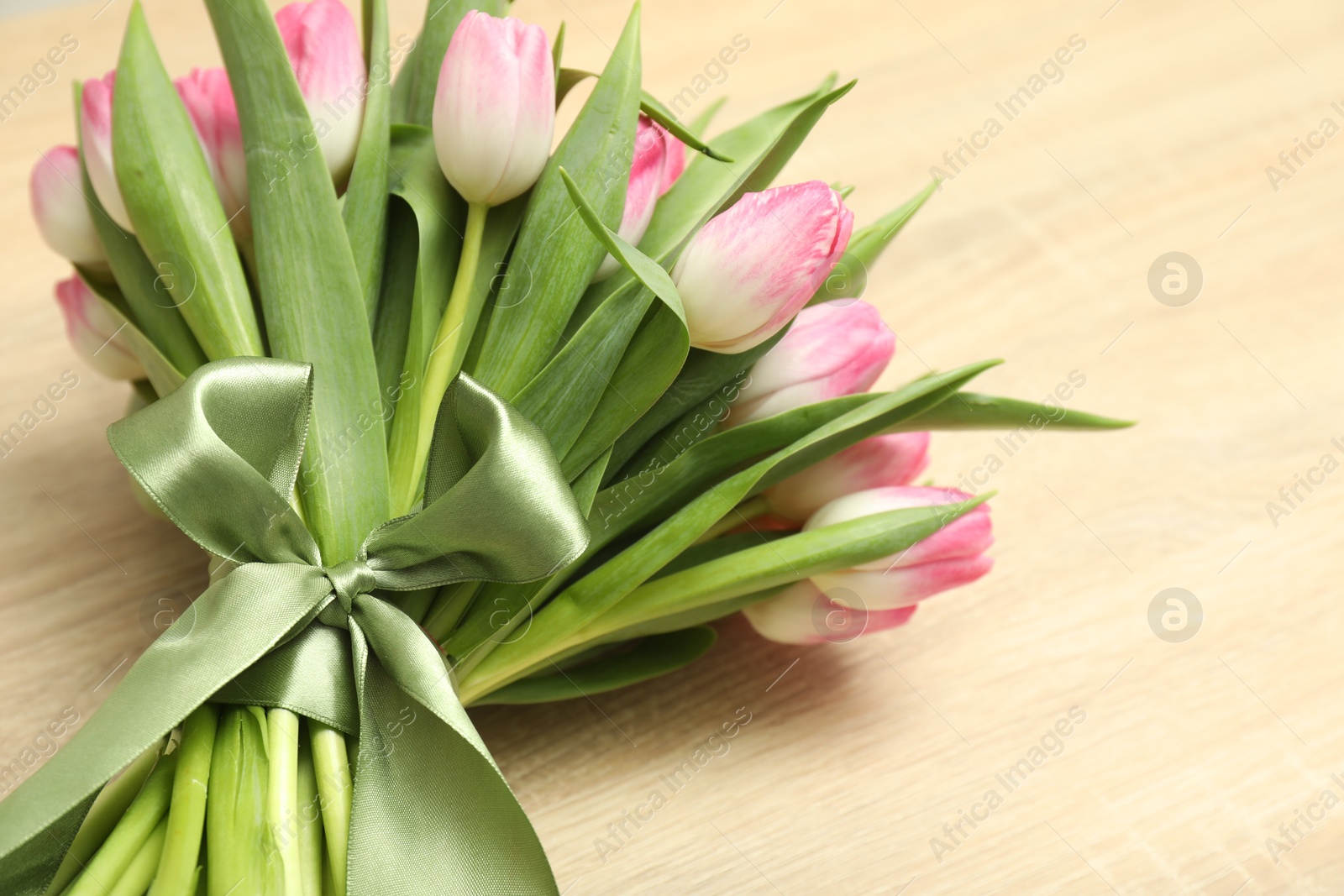 Photo of Bouquet of beautiful tulips on wooden table, closeup. Space for text