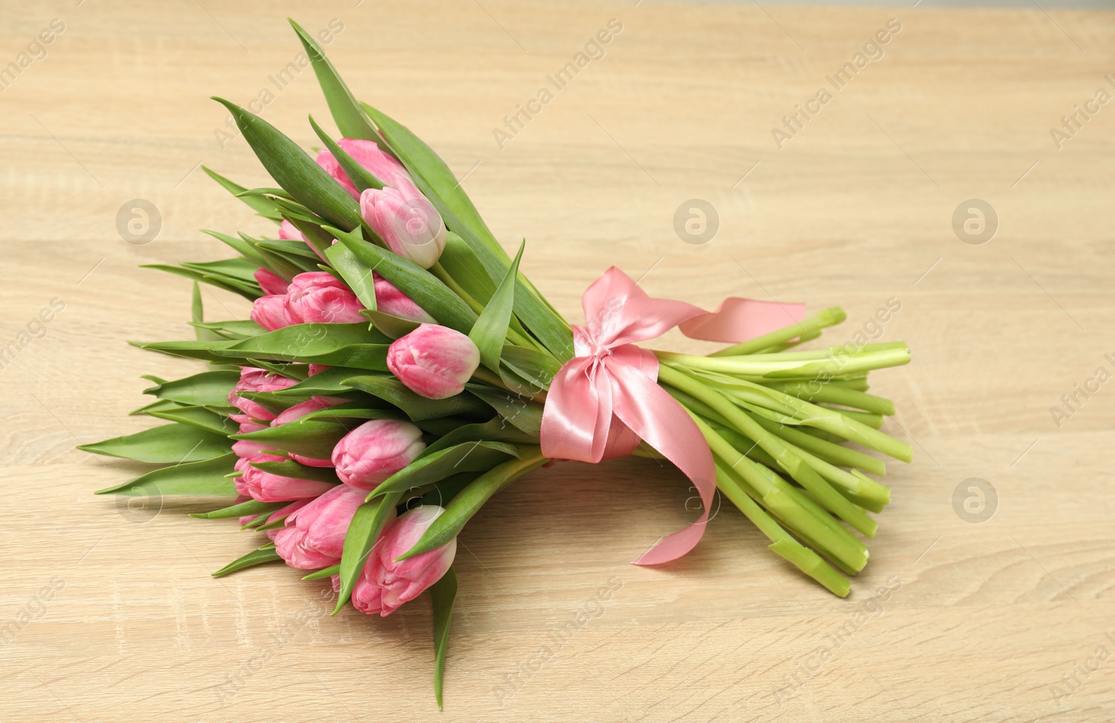 Photo of Bouquet of beautiful tulips on wooden table