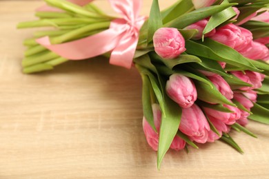 Photo of Bouquet of beautiful tulips on wooden table, closeup. Space for text