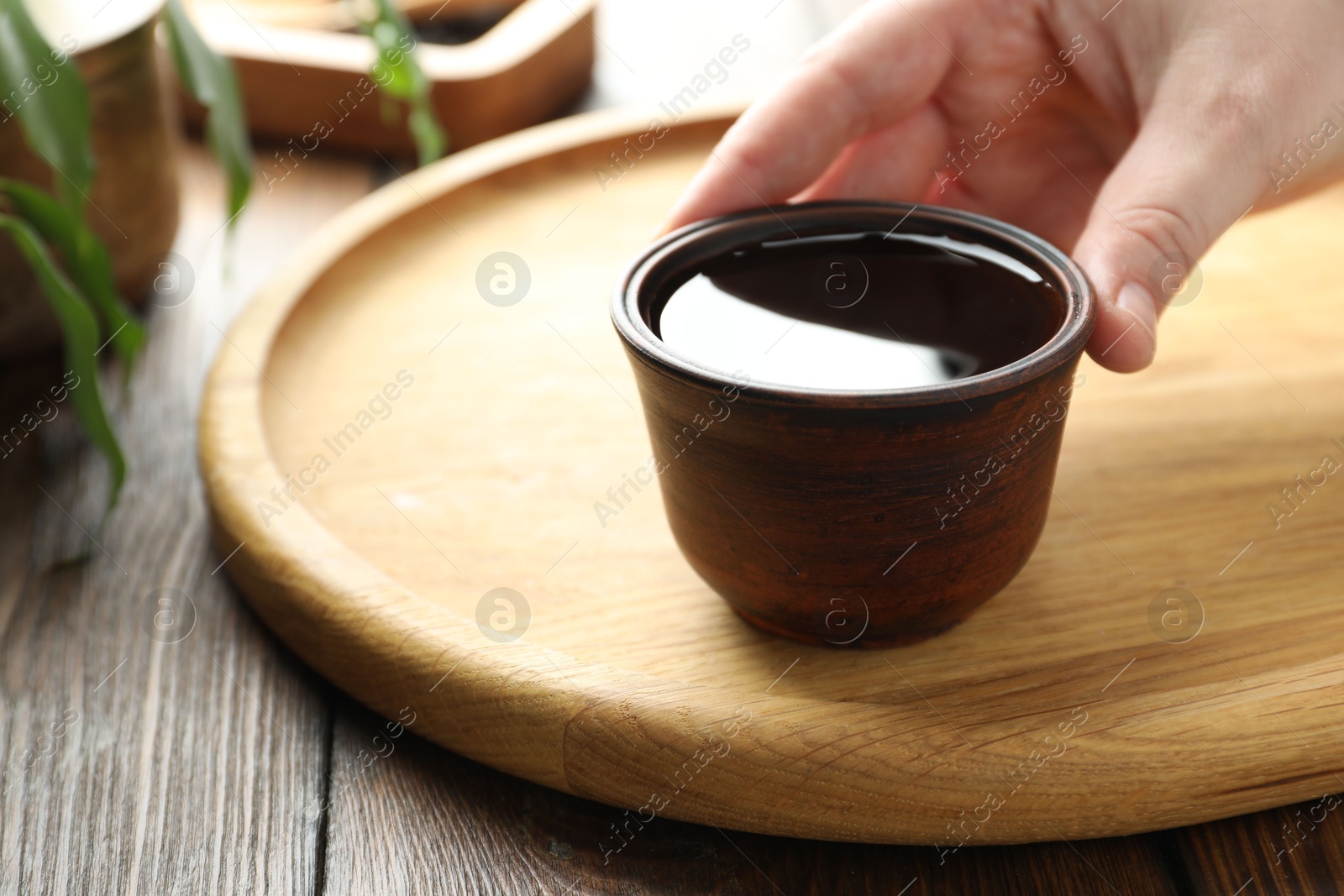 Woman with freshly brewed tea at wooden table, closeup Photo of Woman with freshly brewed tea at wooden table, closeup