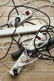 Photo of Extension power boards overloaded with plugs on wooden floor