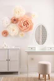 Photo of Beautiful decorative paper flowers on wall in room