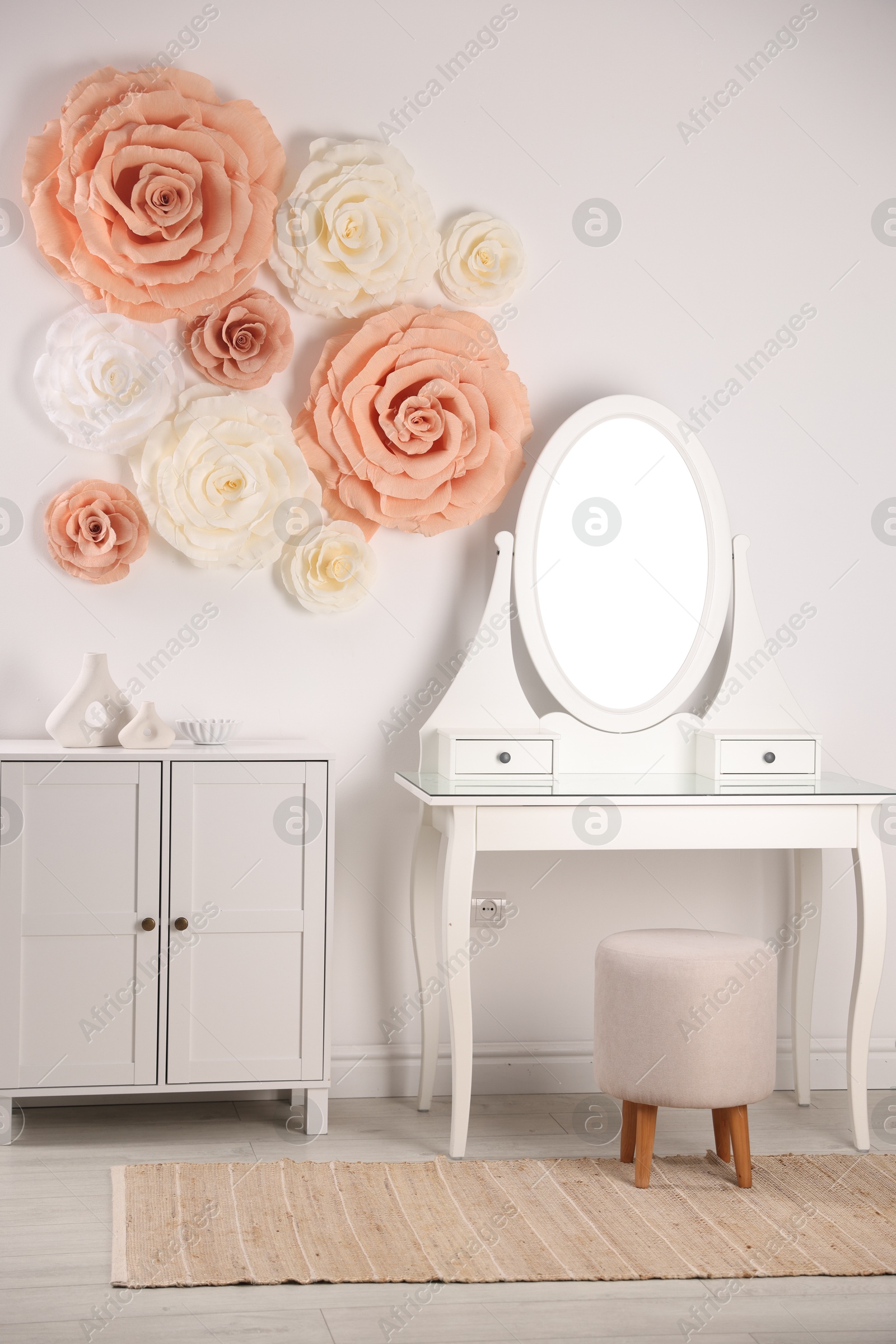 Photo of Beautiful decorative paper flowers on wall in room