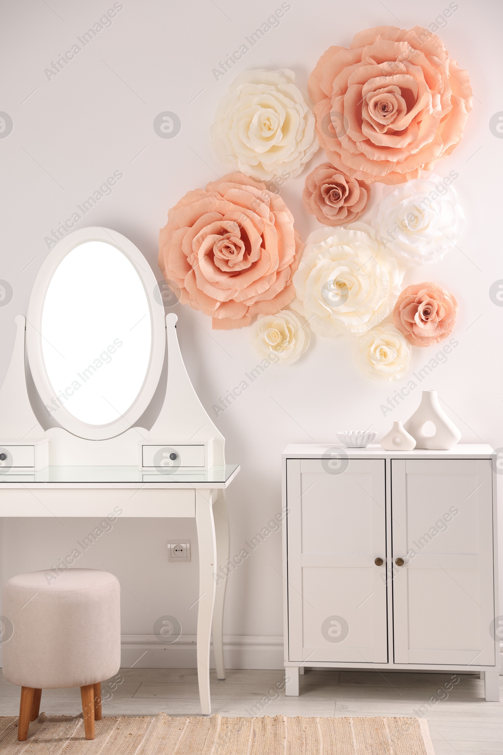 Photo of Beautiful decorative paper flowers on wall in room