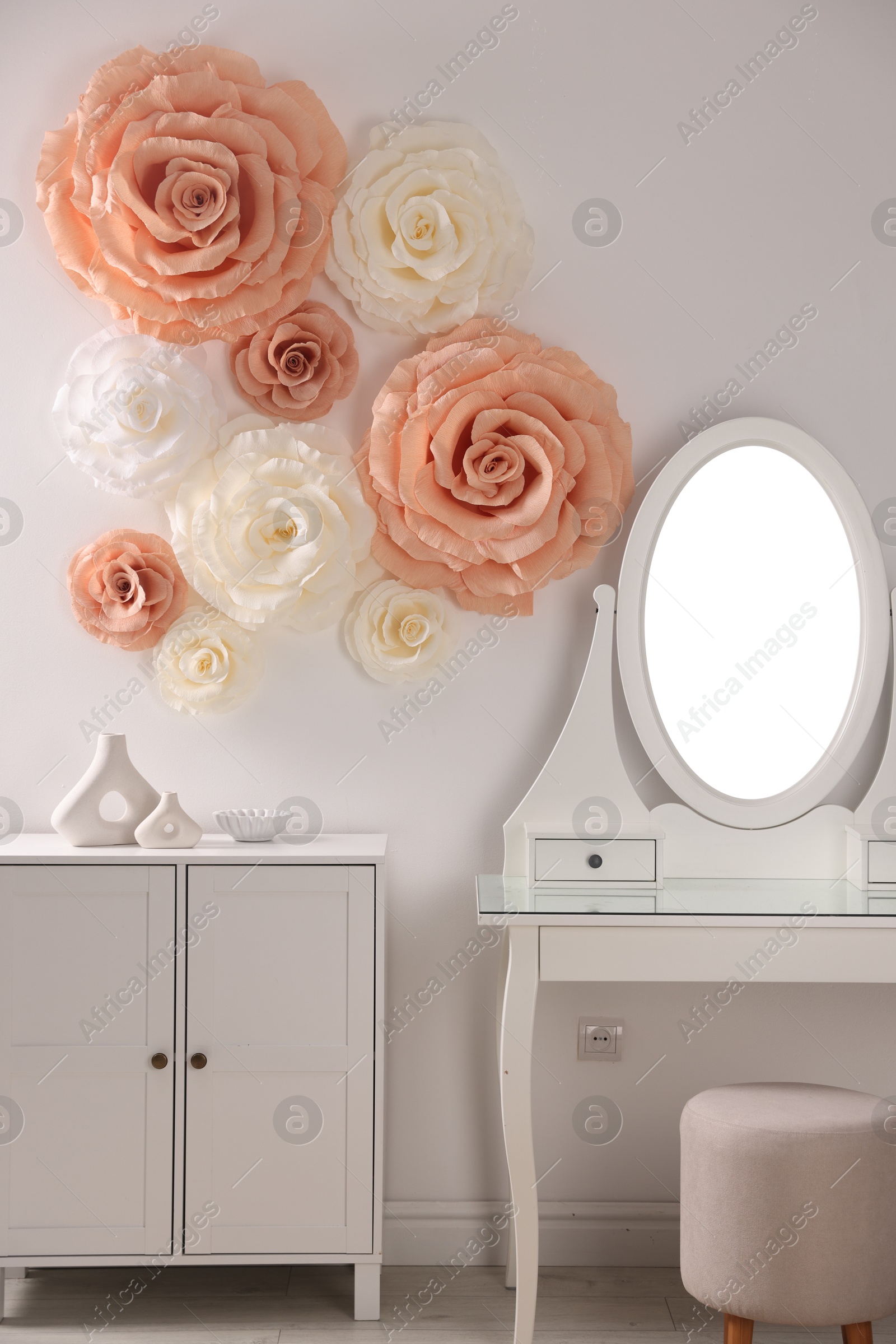 Photo of Beautiful decorative paper flowers on wall in room