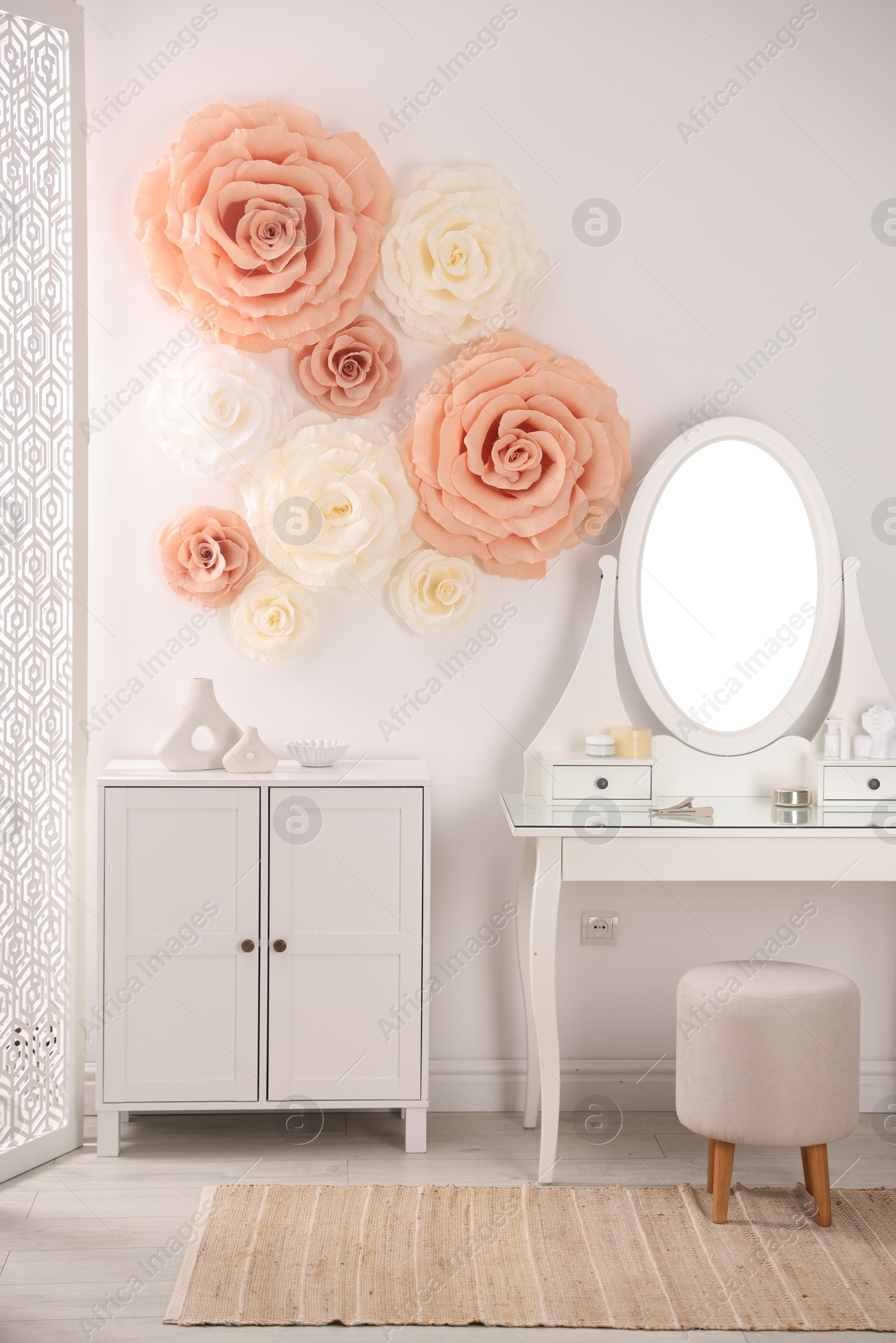 Photo of Beautiful decorative paper flowers on wall in room