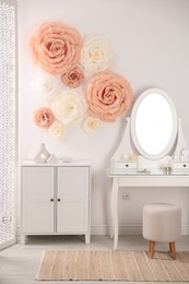 Photo of Beautiful decorative paper flowers on wall in room