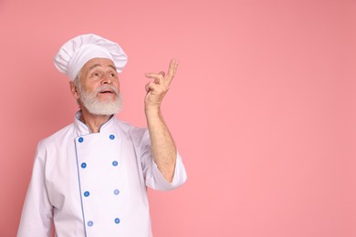 Photo of Portrait of professional pastry chef on pink background, space for text