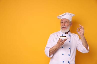 Professional pastry chef with delicious tart showing ok gesture on orange background, space for text