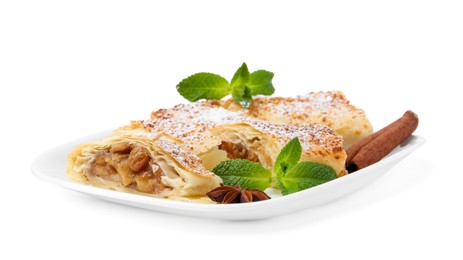 Photo of Tasty apple strudels with powdered sugar, mint and spices isolated on white