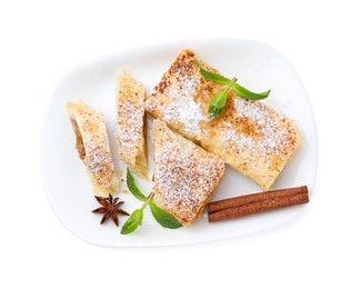 Tasty apple strudels with powdered sugar, mint and spices isolated on white, top view