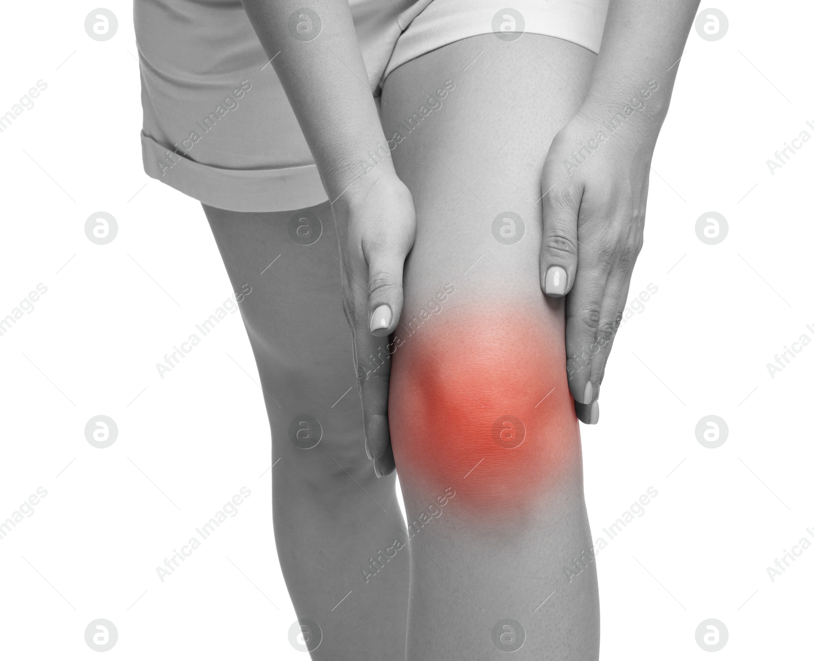 Image of Young woman suffering from pain in knee on white background, closeup. Black-and-white effect with red color accent