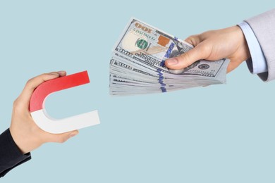 Image of Sponsor offering dollar banknotes to man with magnet on light blue background, closeup