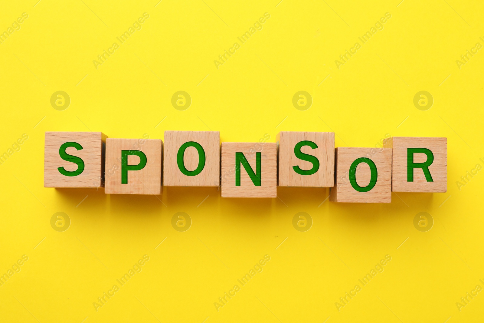 Image of Word Sponsor made of wooden cubes with letters on yellow background, top view