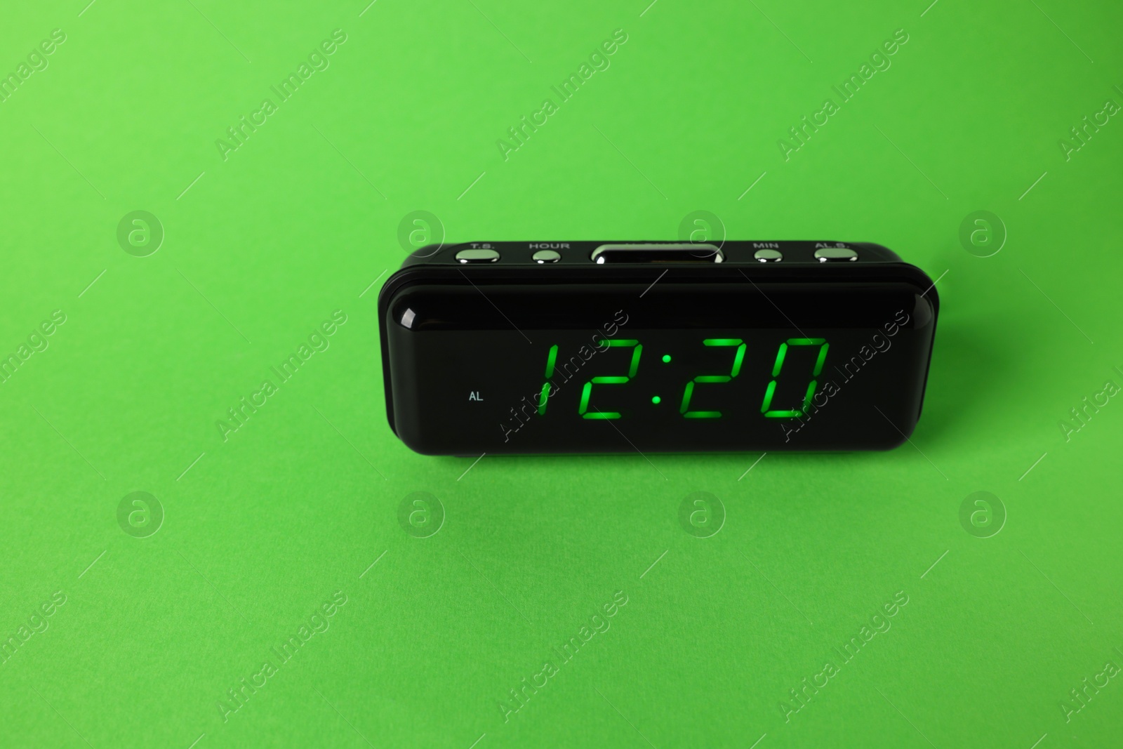 Digital alarm clock showing 12:20 o'clock on green background, space for text Photo of Digital alarm clock showing 12:20 o'clock on green background, space for text
