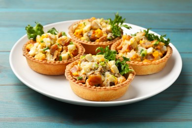 Photo of Tartlets with delicious filling on blue wooden table, closeup