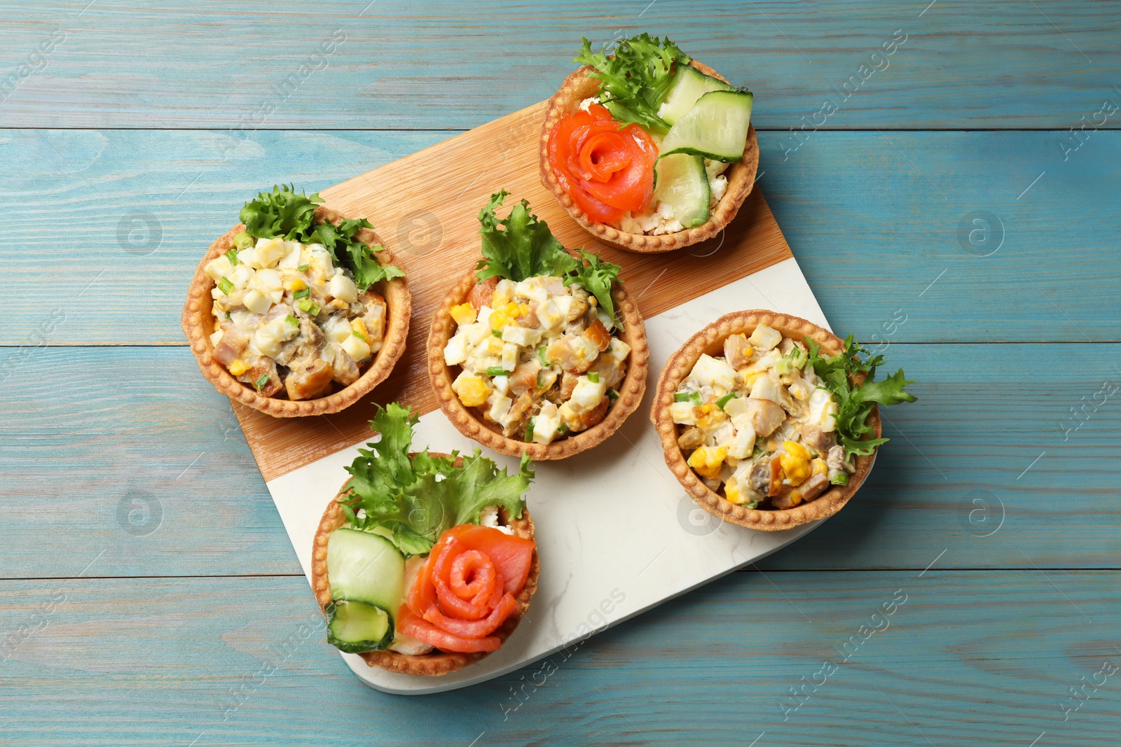 Tartlets with delicious fillings on blue wooden table, top view Photo of Tartlets with delicious fillings on blue wooden table, top view