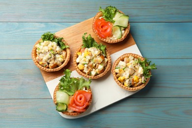 Photo of Tartlets with delicious fillings on blue wooden table, top view