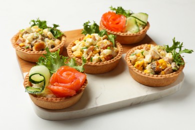 Photo of Tartlets with delicious fillings on white table, closeup