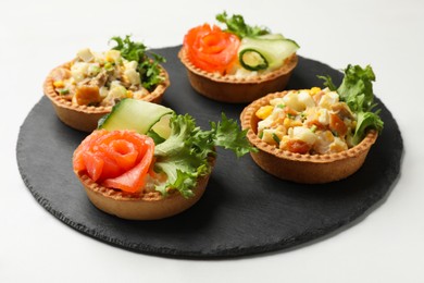 Photo of Tartlets with delicious fillings on white table, closeup