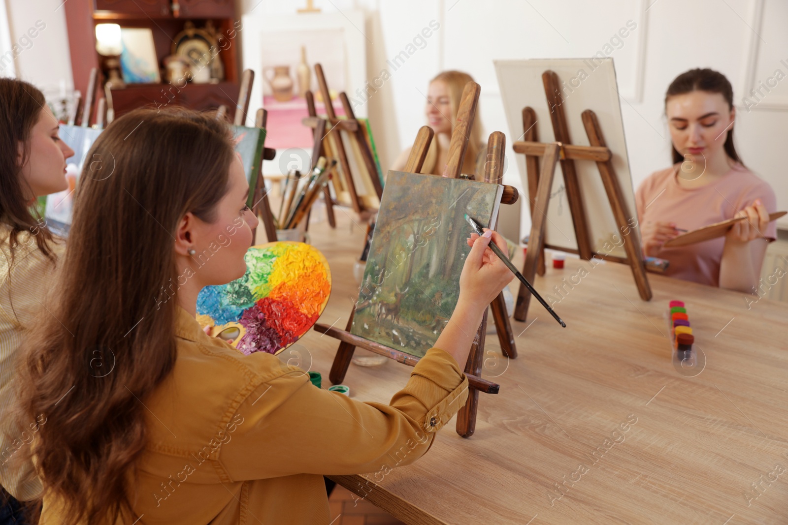 Photo of Group of women learning to draw at table in class