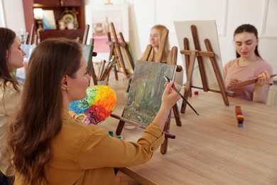 Group of women learning to draw at table in class