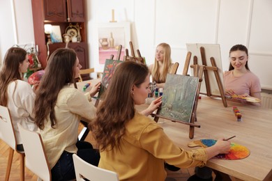 Group of women learning to draw at table in class