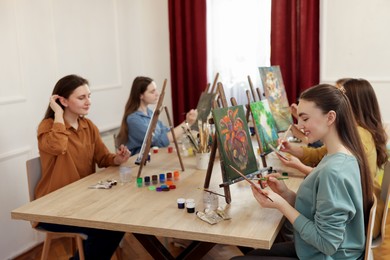 Group of women learning to draw at table in class