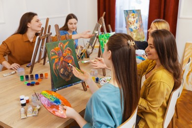 Group of women learning to draw at table in class