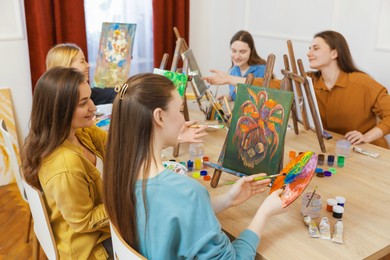 Group of women learning to draw at table in class