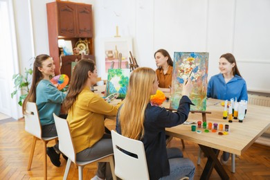 Group of women learning to draw at table in class