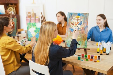 Photo of Group of women learning to draw at table in class