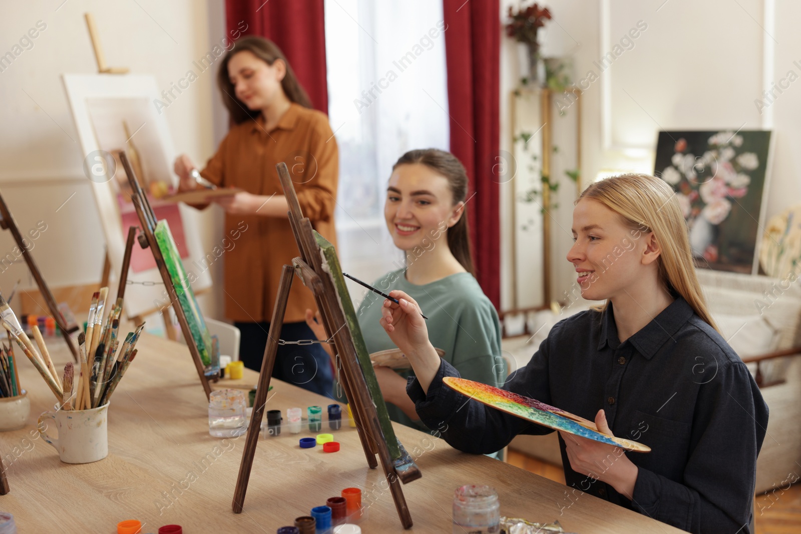 Photo of Group of women learning to draw at wooden table in class