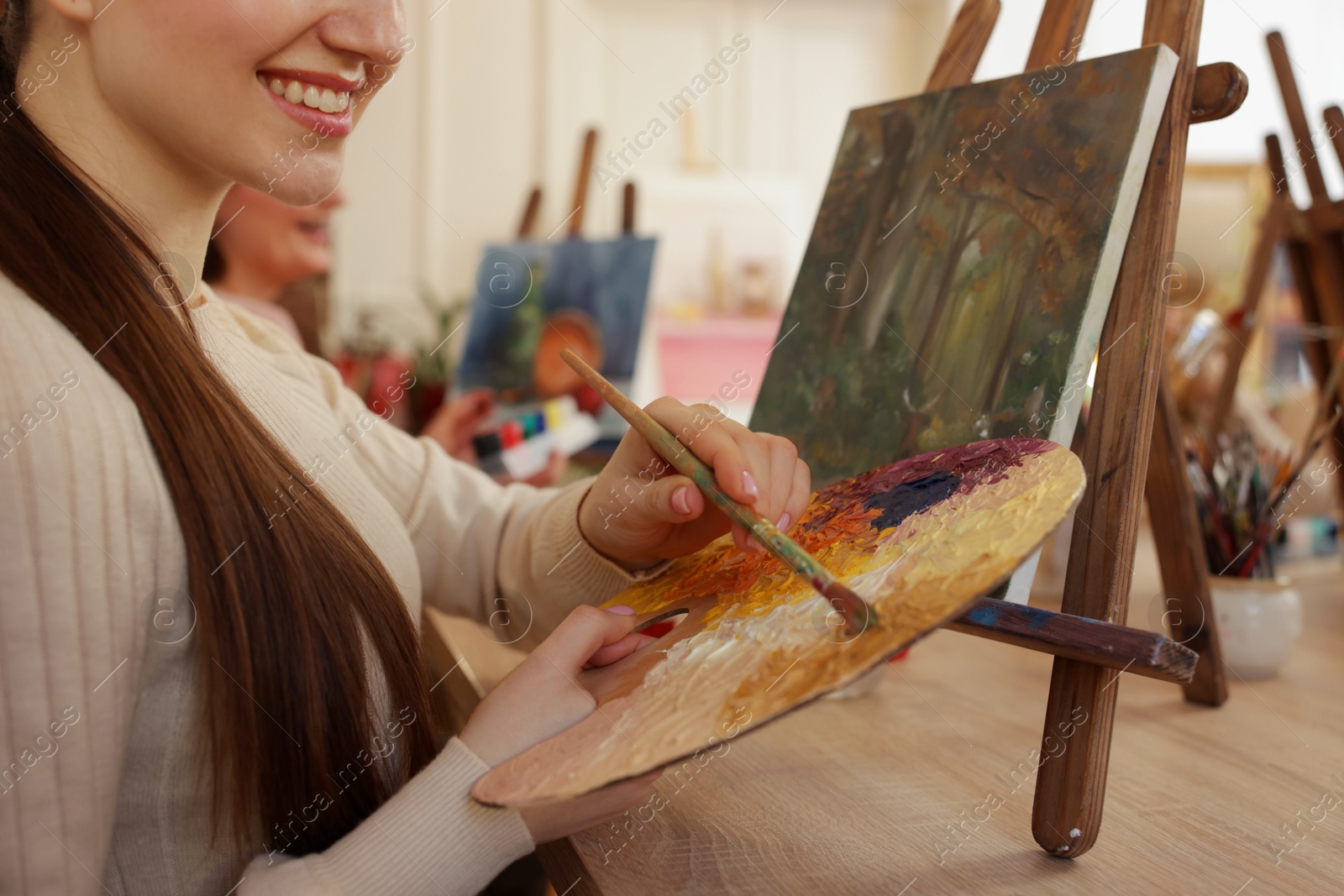 Photo of Women learning to draw at wooden table in class, closeup