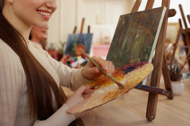 Women learning to draw at wooden table in class, closeup