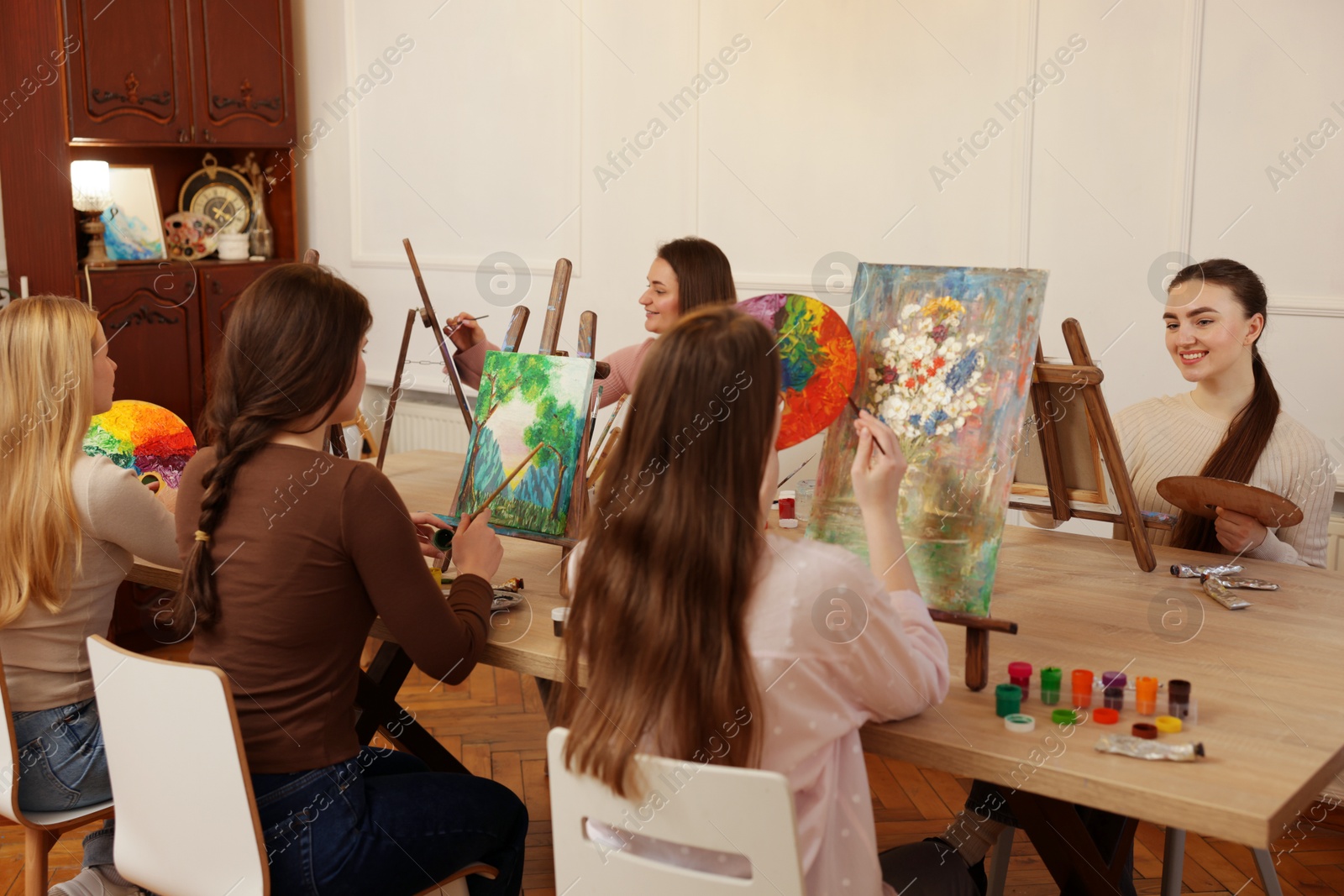 Photo of Group of women learning to draw at wooden table in class