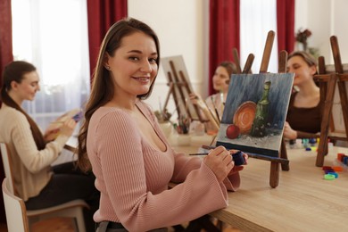 Group of women learning to draw at table in class