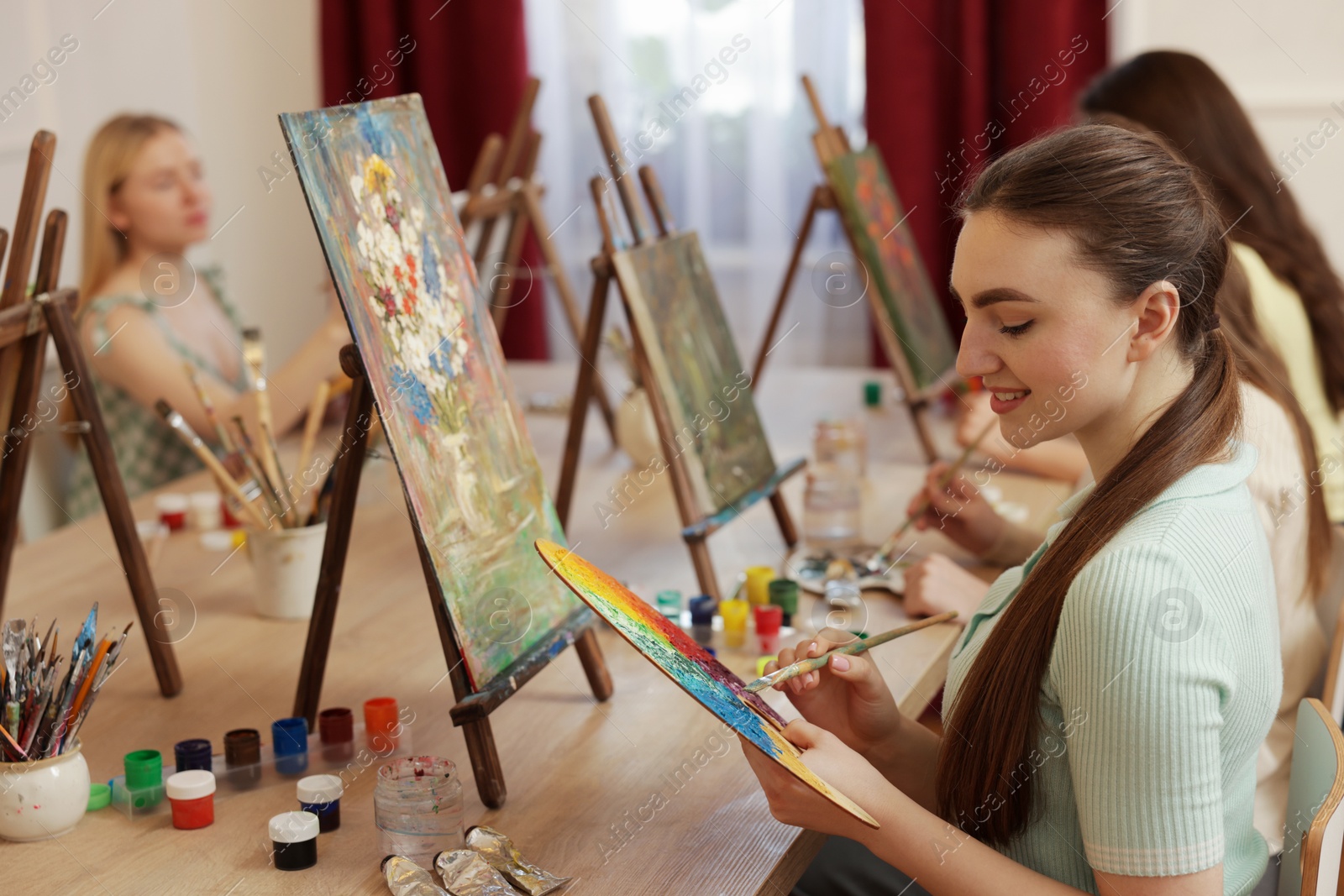 Photo of Group of women learning to draw at wooden table in class