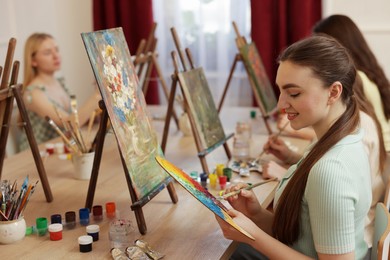 Group of women learning to draw at wooden table in class