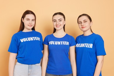 Portrait of smiling volunteers on beige background