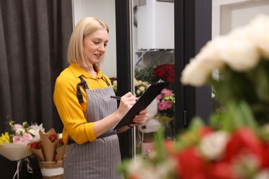 Business owner with clipboard taking notes in her flower shop