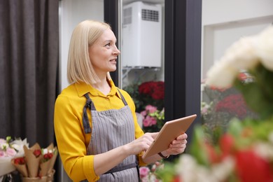 Photo of Business owner with tablet in her flower shop