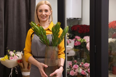 Business owner with green plant in her flower shop