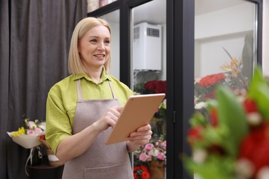 Photo of Business owner with tablet in her flower shop