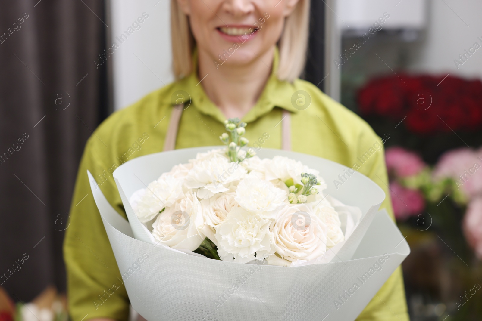 Photo of Business owner with beautiful bouquet in her flower shop, closeup