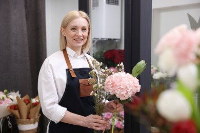 Photo of Business owner making beautiful bouquet in her flower shop