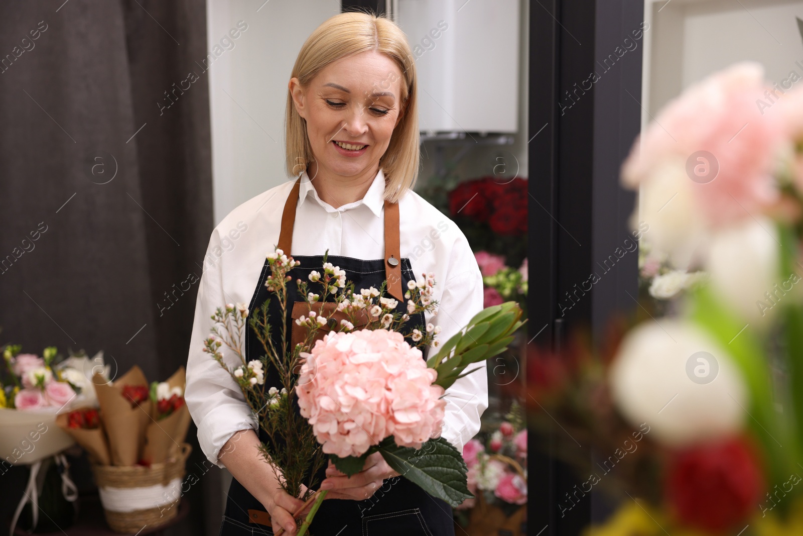 Photo of Business owner making beautiful bouquet in her flower shop