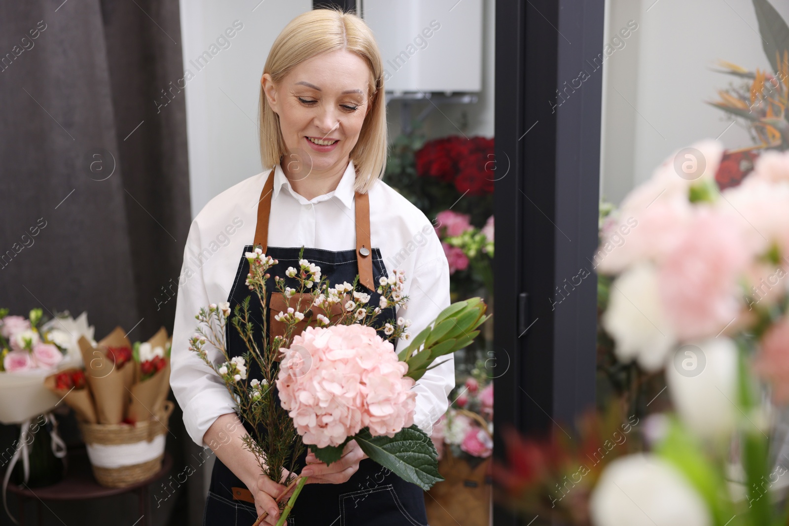 Photo of Business owner making beautiful bouquet in her flower shop