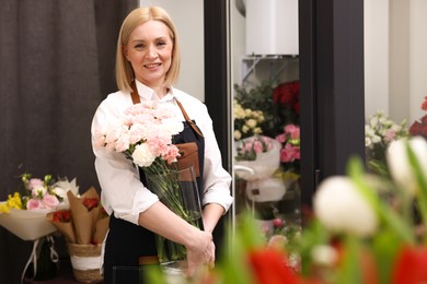 Business owner with beautiful carnations in her flower shop